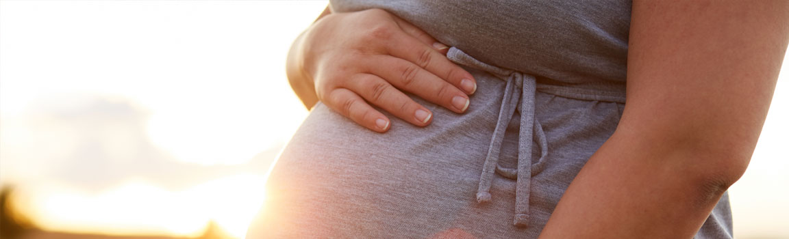 A pregnant woman is holding her belly