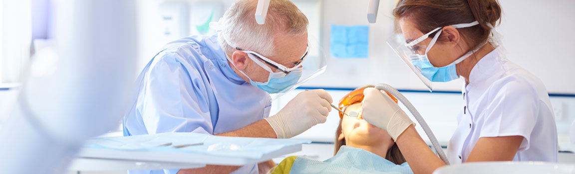 Two dentists are performing a procedure on a patient